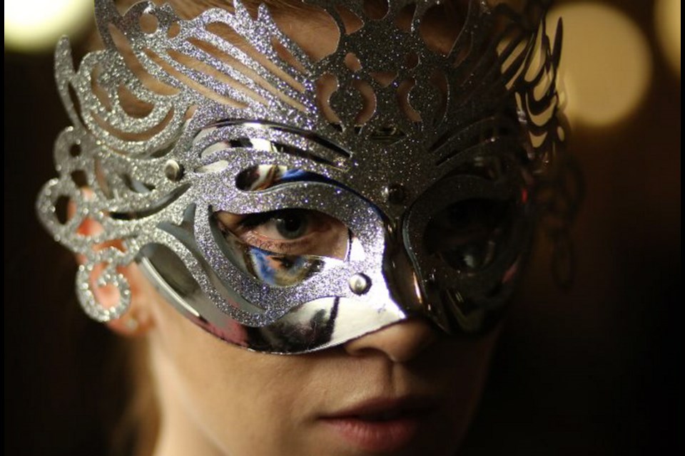Adrienne Olley looks suitably mysterious under a glittering silvery mask.