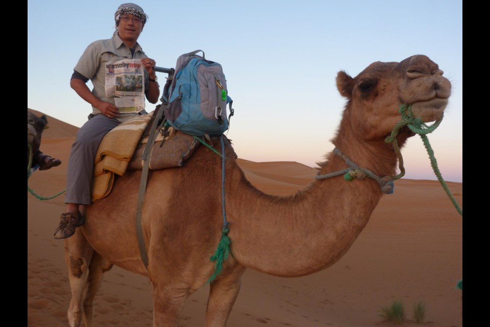 Tom Wong riding a camel in the Sahara Desert near Merzouga, Morocco.