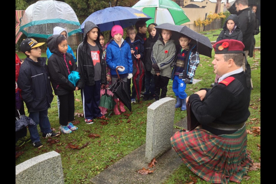 Lest we forget: Robert Rathbun, member of the Society of Officers of the Honourable Guard, tells the story of a war veteran from New Westminster to a group of Grade 4 and 5 students from Richard McBride elementary.