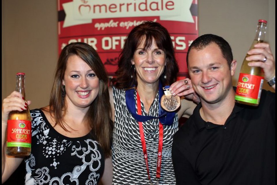 Holding gold: Holly Child, left, and Jason Child flank Olumpic medalist Julie Skinner.