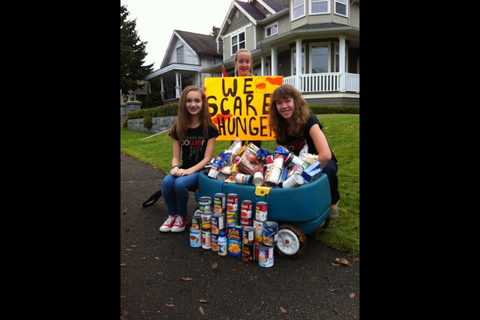 Scaring up some food: Dressed as bedheads, Rachel Way, Cara Falcone and Mikayla Greenwood took part in a We Scare Hunger event and collected non-perishable food items for the food bank. The girls were inspired by We Day and are already planning future projects.