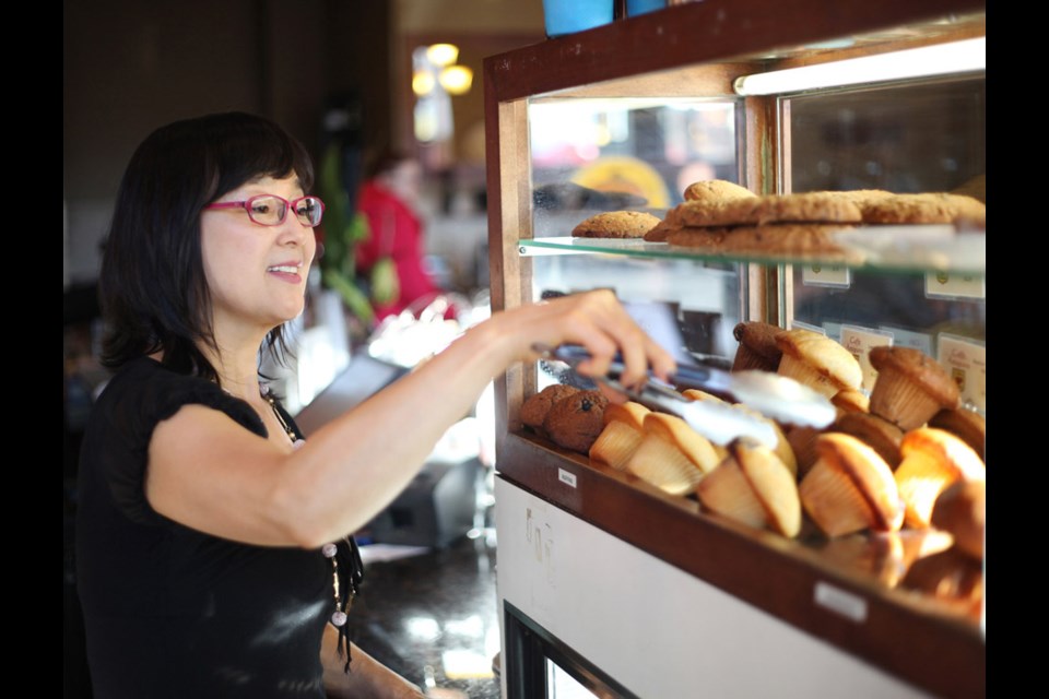 Tasty treats: Caffe Artigiano employee Michelle Savenye serves up some of the baked goods available at the café, which opened in the Heights five years ago. The café is just one of many unique coffee shops spread throughout the neighbourhood.