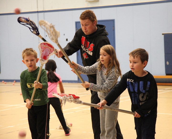 Stick skills: New Westminster Salmonbellie Blake Duncan teaches target practice to some Lord Kelvin Elementary School students taking part in a lacrosse program sponsored by the New Westminster Minor Lacrosse Association.