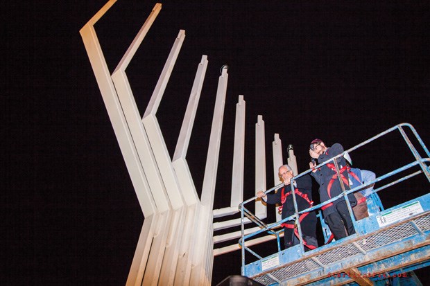 Photo by Glenn Berlow Mayor Malcolm Brodie prepares to light the first candle on the city hall menorah on Wednesday.