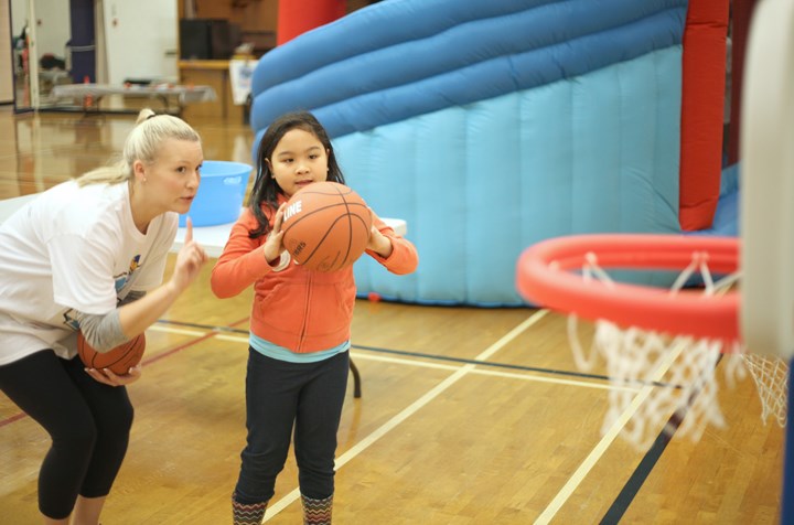 Helpful hints: Lilac Quiapo gets some shooting tips from instructor Gemma Beint at the Let’s Get Active event at Centennial Community Centre. The Nov. 30 event was in celebration of national Child Day and Sports Day in Canada.