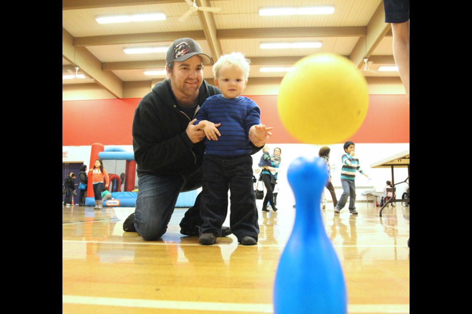 Going for a strike: Chris Freeman helps his son Nathaniel knock down some bowling pins at he Let’s Get Active event held at Centennial Community Centre on Nov. 30.