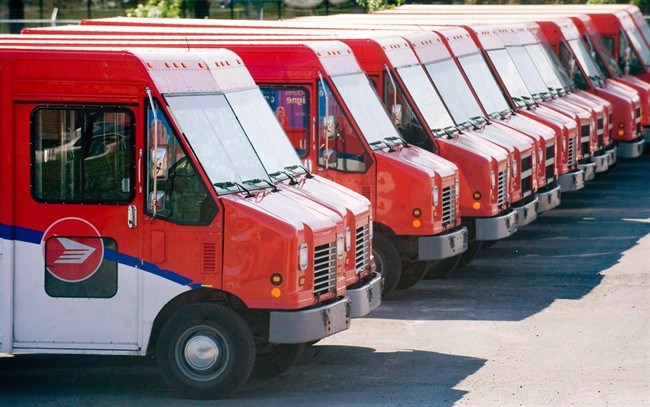 Canada Post vehicles sit outside a sorting depot in the Ville St-Laurent borough of Montreal, in a J