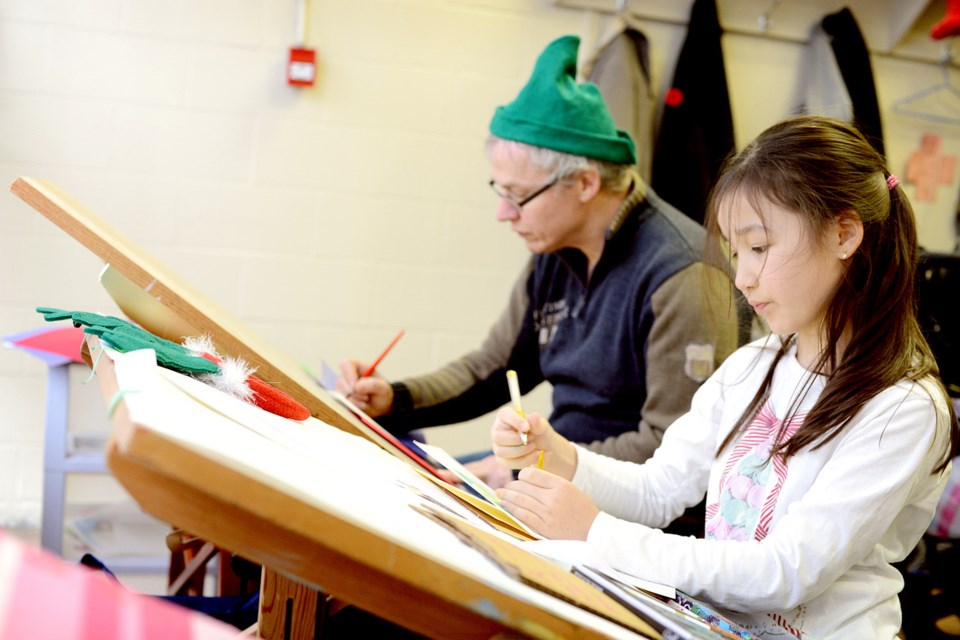 Nine-year-old Kayla McElheron and father Derek make Christmas cards during the Artists Helping Artists Christmas party in Burnaby.