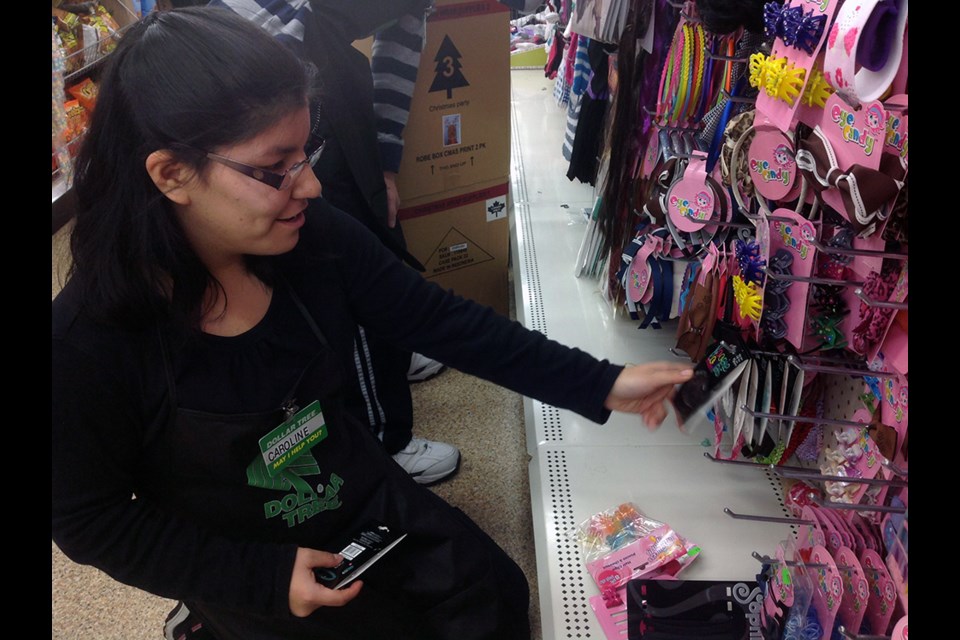 Caroline Woodhouse busy at work at the Dollar Tree on Hastings Street in Burnaby's Heights neighbourhoood. Woodhouse started at the Dollar Tree as a student in a work experience program at Alpha Secondary, but now she works in the store part-time and earns her own wage.