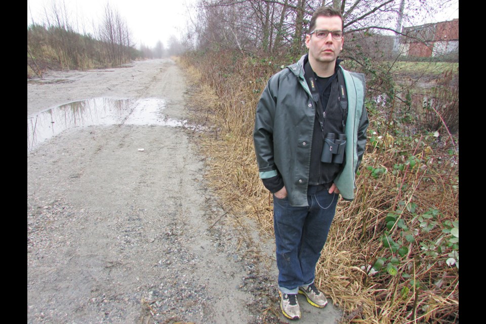 Burnaby resident and biology instructor Cameron MacDonald has concerns that a development in the south of the city is too close to Byrne Creek. The setback area behind him was cleared of all vegetation and covered in sand, but the city says it will be replanted.