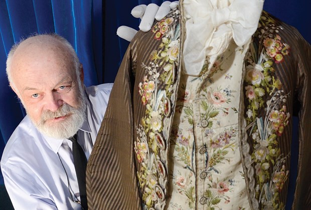 Fashion historian Ivan Sayers gently handles a late-18th-century men’s silk-embroidered vest and jacket from Vienna, among the many garments in his collection that will be showcased at Lions Gate Sinfonia’s Music and Fashion event this Sunday.