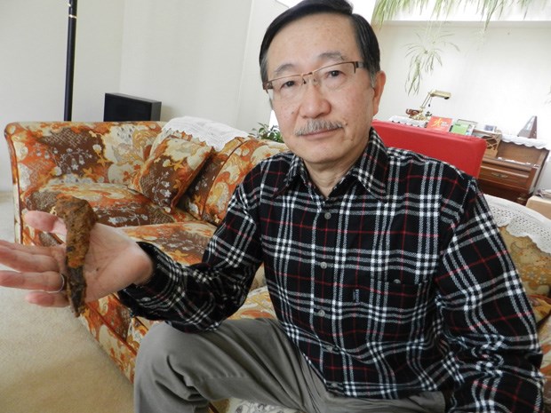 Bill Chu, of the Canadians for Reconcilliation Society, holds up a railway spike, a relic from the railroad building efforts through the Fraser Canyon by Chinese immigrants.