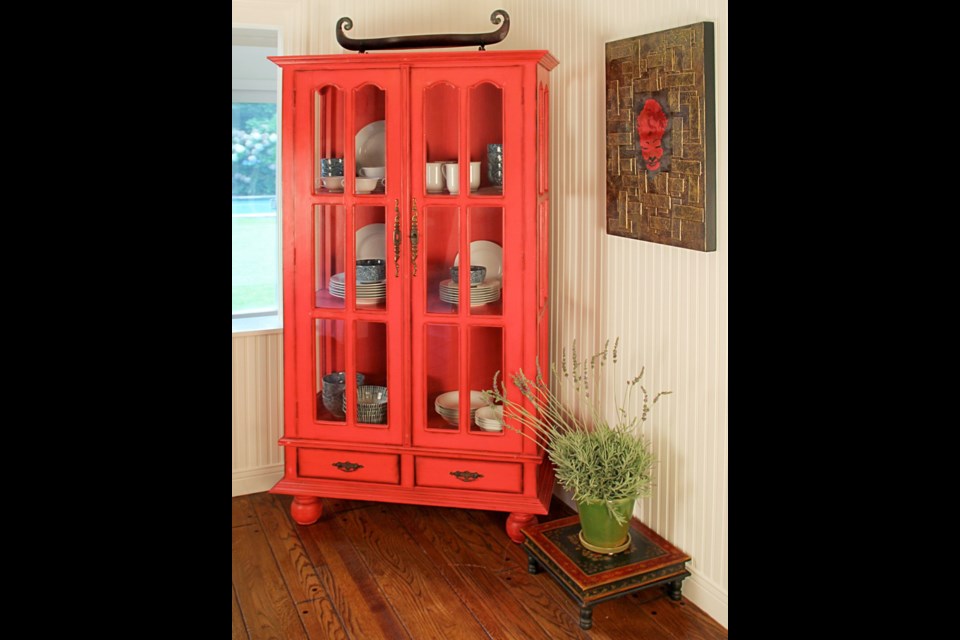 Free-standing cabinets, such as this bright red, glass fronted unit, are a terrific choice for apartments or houses with tiny kitchens.