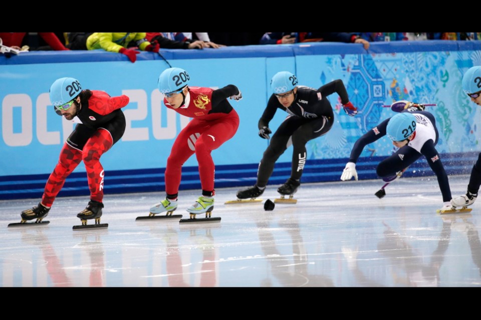 Jack Whelbourne of Britain, right, crashes out as Charles Hamelin of Canada, left, Han Tianyu of China, centre, and J.R. Celski of the United States, third from left, compete in a men's 1500m short track speedskating final at the Iceberg Skating Palace during the 2014 Winter Olympics, Monday, in Sochi, Russia.