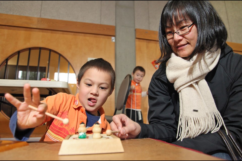 Mami Towsley with son Lukas playing sumo tops at the Nikkei Centre Family Games Day.