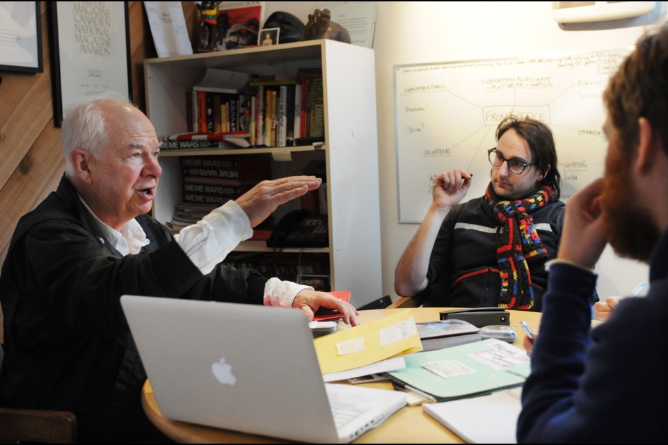 Kalle Lasn (left) leads a staff meeting for an upcoming issue of Adbusters magazine inside its Fairview headquarters. photo Dan Toulgoet