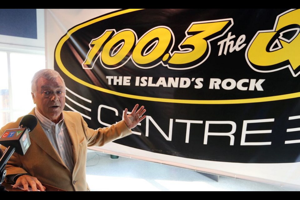 General manager of 100.3 The Q! (CKKQ-FM) Dan McAllister unveils the new logo during a press conference for the re-naming of Bear Mountain Arena.
