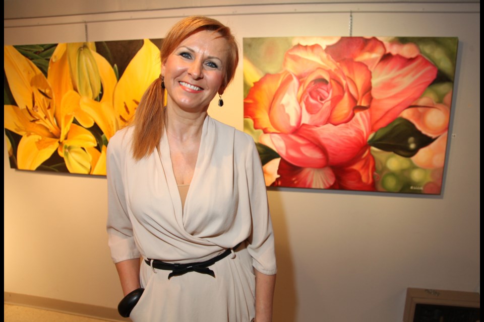 Grazyna Wolski with her paintings at the opening reception for the show Floriography at the Arts Council of New Westminster Gallery. It's on until March 29.