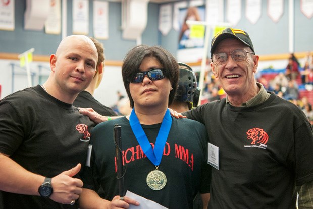 Johnny Tai shows off his gold medal.