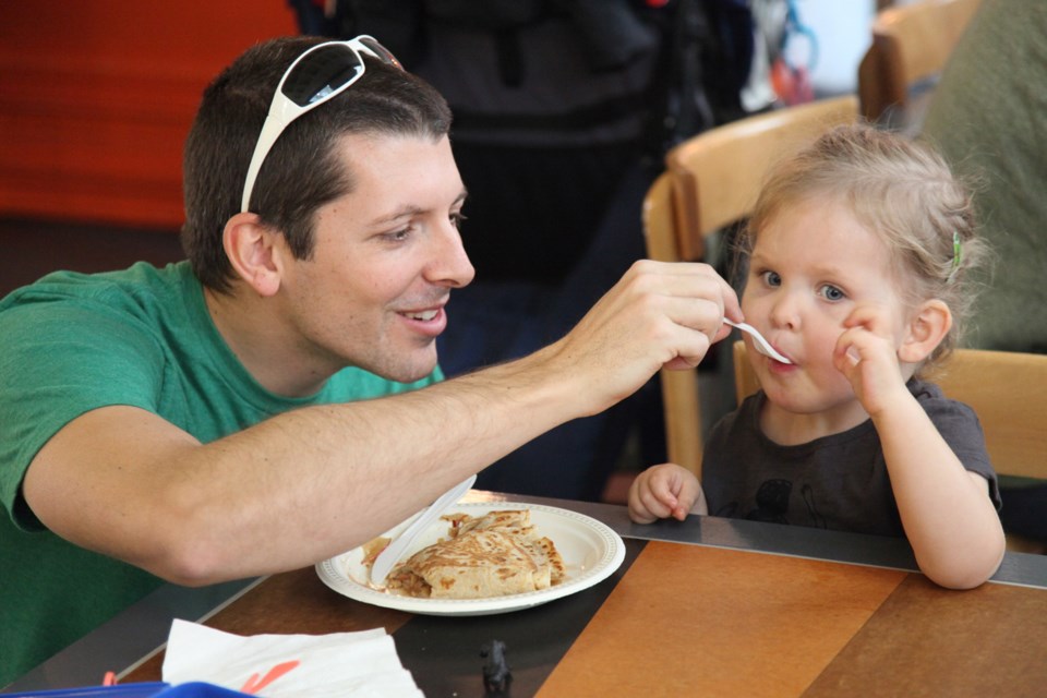 Neil Zandbergen feeds crepes to his daughter Kayla at the River Market, one of our top picks for family-friendly dining in New West.