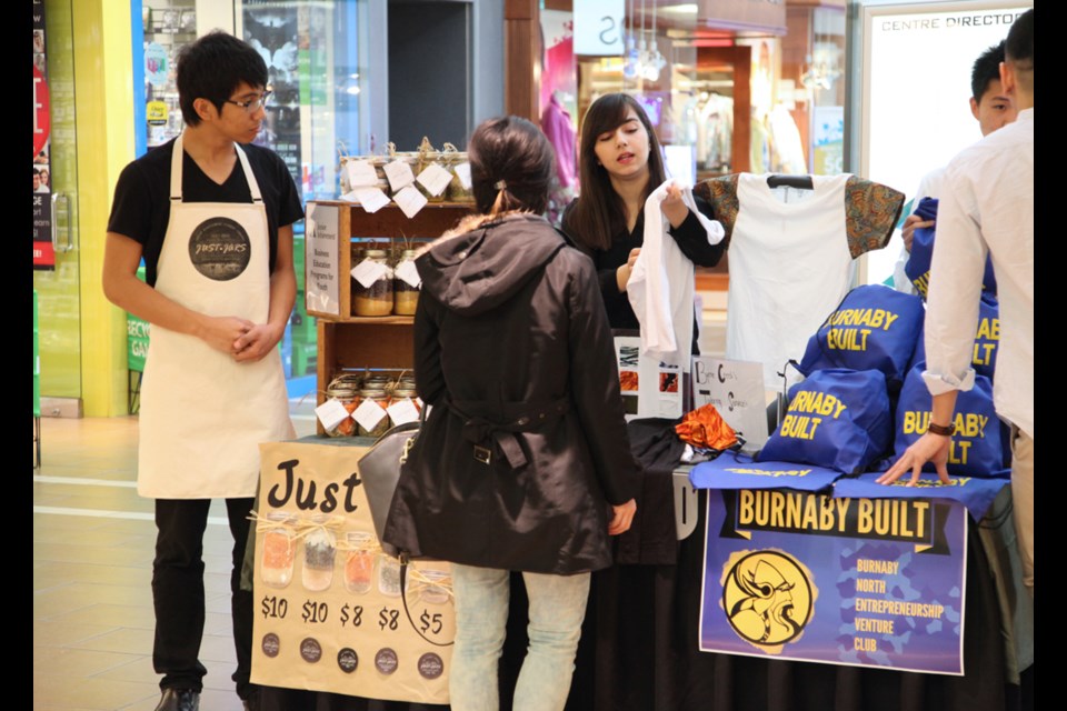 Burnaby South student Earl Villarosa selling ready-to-cook meals in jars and Byrne Creek student Dunya Aziz selling items at Brentwood mall as part of the Junior Achievement Company program.