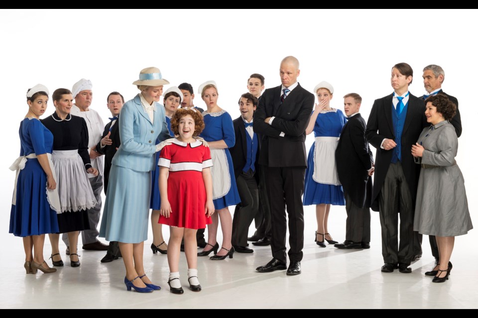 The cast of the Royal City Musical Theatre production of Annie, including New West's Cassady Ranford (front, in blue suit) as Grace, Julia MacLean as Annie and Steve Maddock as Daddy Warbucks.