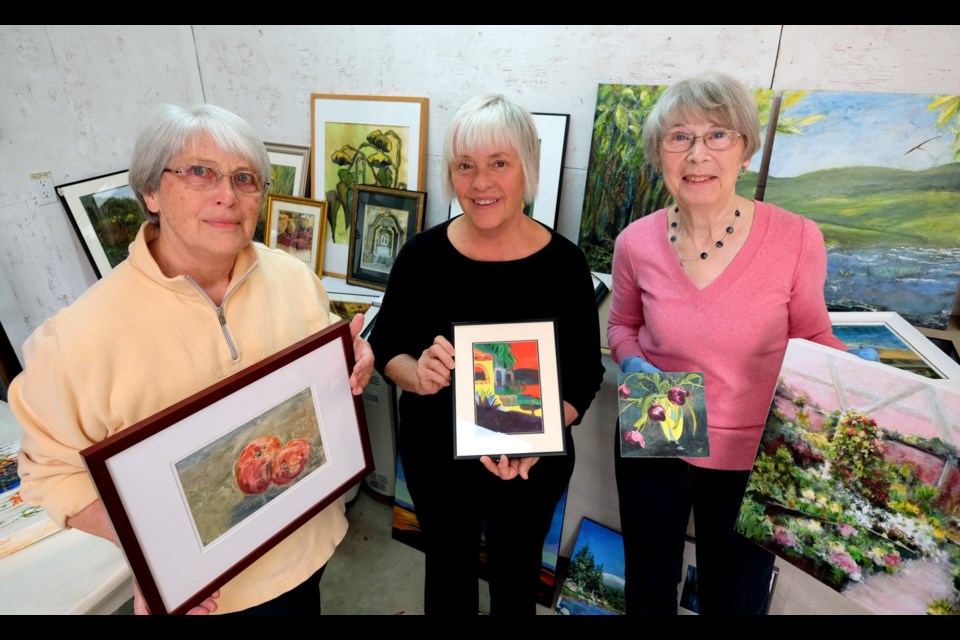 From left, Pat Sexsmith, Dianne Yard and Sheila Chowdhury with their artwork. They're getting ready for the Gamma Garage Art Show next weekend.