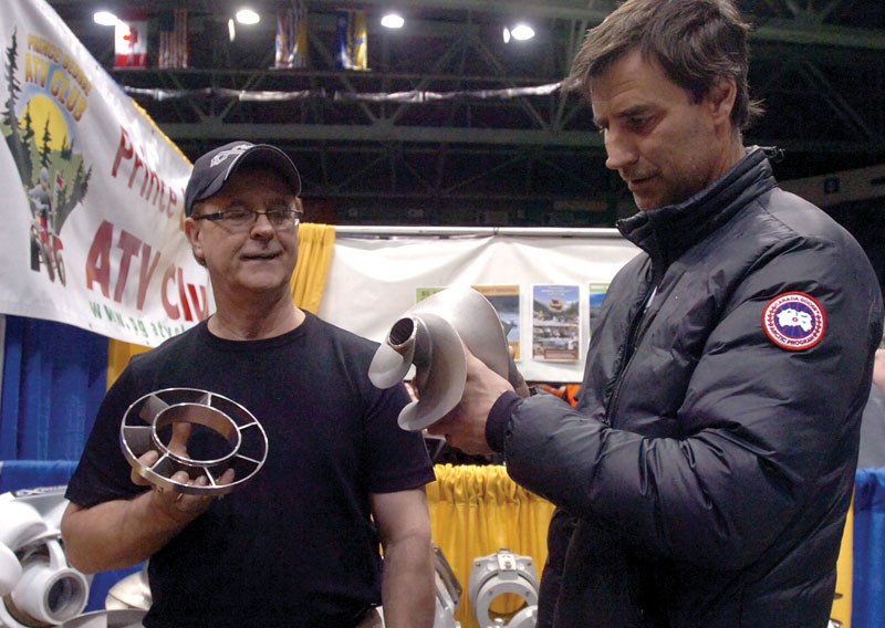 Claude L'Heureaux, left, and Chris Dunn look at the 3 blade skew impellor at the Exact Welding booth.