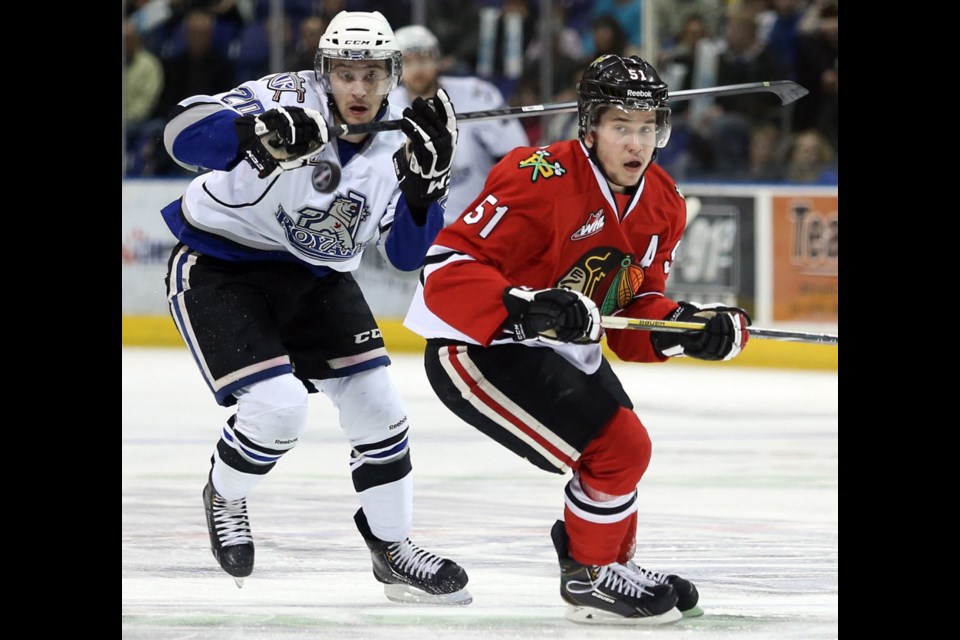 Royals forward Logan Fisher and Winterhawks defenceman Derrick Pouliot track the puck during Game 4 on Tuesday.
