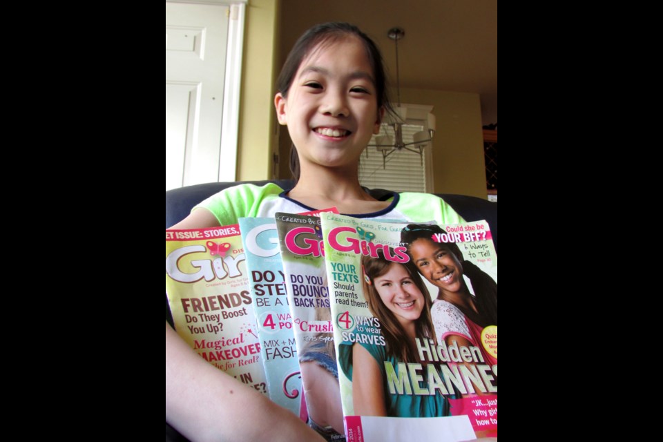 Emily Luu with a stack of Discovery Girls magazines. The New West resident is one of six girls from around North America featured in the April-May issue.