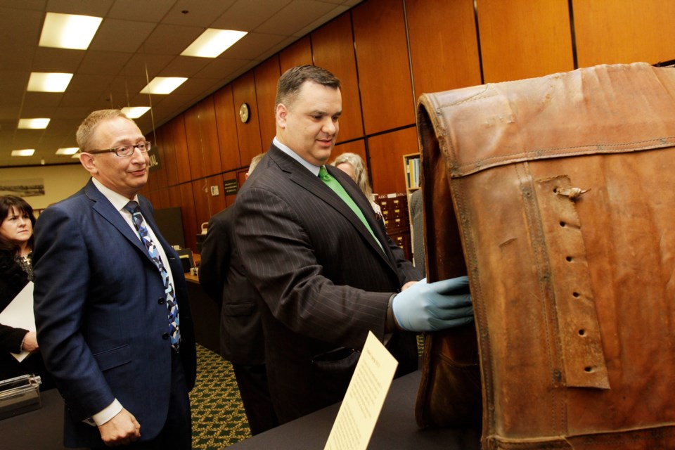 Royal B.C. Museum CEO Jack Lohman, left, guides Federal Heritage Minister James Moore on a tour of the museum. Here, they examine a pack saddle worn by a horse or mule during the province's mid-19th century gold rush.