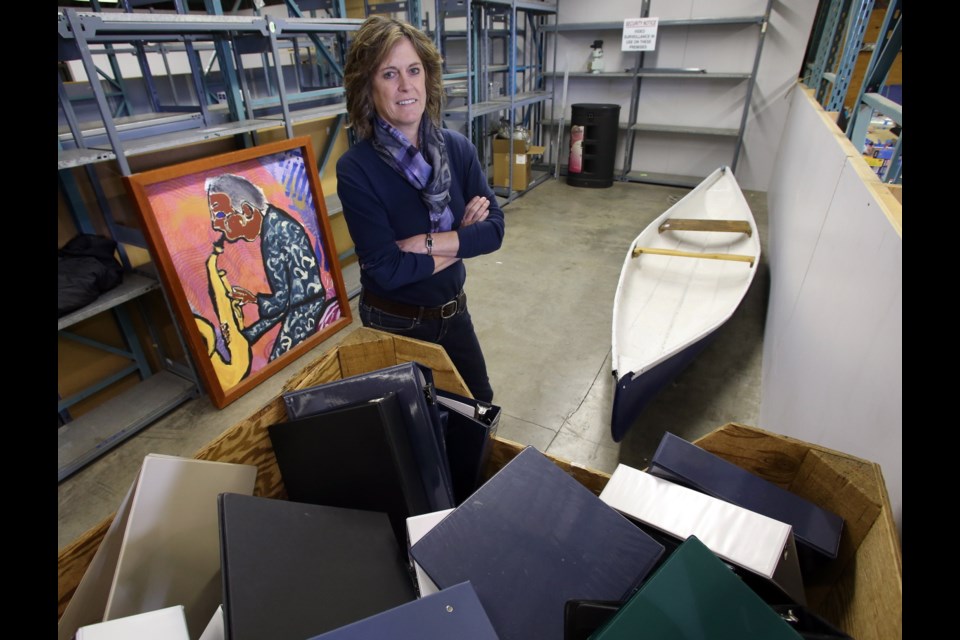 Saturday: Leslie Walden, director of the B.C. Asset Management and Distribution Centre, with some items that are for sale, including a canoe and work of art that are selling on the B.C. Auction website, plus binders that are part of the cash-and-carry offerings at the centreês Glanford Avenue site.
