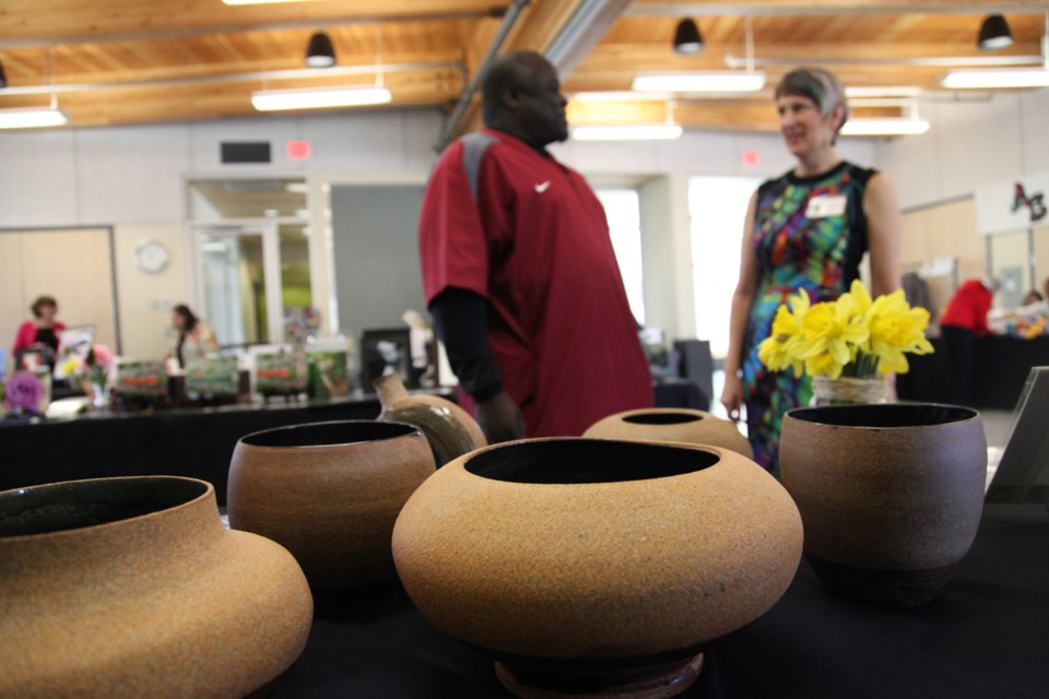 Floyd Sandiford and Dale Costanzo chat in front of Sandiford's pottery at the Artists in the Boro Spring Fling, held April 13 at Queensborough Community centre.
