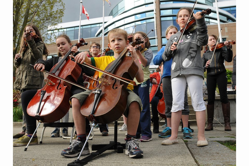 Seven-year-old cello player Keith Topnik and string students from several elementary schools got together to play a few songs before the meeting at the VSB Education Centre Tuesday afternoon. Photo Dan Toulgoet