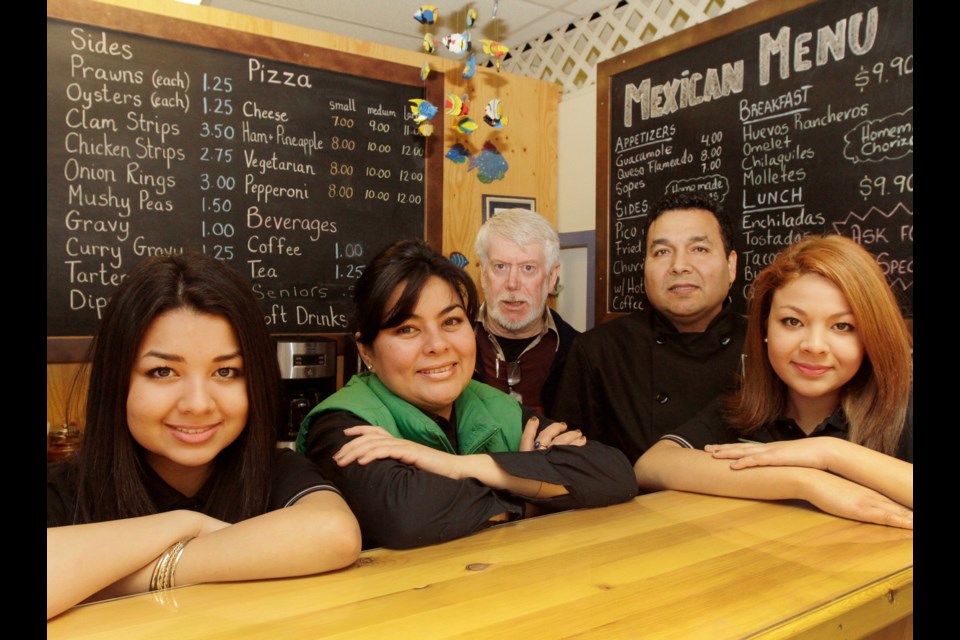 Kel Martin, owner of Gosworth Fish and Chips, a day time restaurant and Ronald Solis, owner Tequila House, an evening restaurant with his family wife Mayte, daughters Cristell, 18 (R), and Mayte, 16.