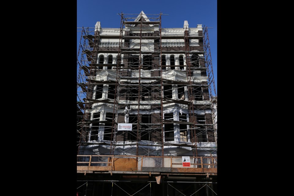 The New England Hotel, built in 1892 on Government Street, near Yates Street, gets a fresh coat of paint in October 2013. The heritage building has been renovated with studio suites on the upper floors and refreshed commercial space on the ground level.