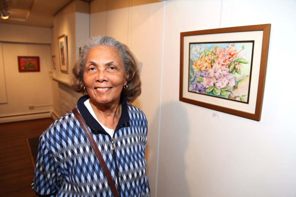 Lily Spence with her work at the Multiple Visions exhibition opening, April 26 at Deer Lake Gallery.