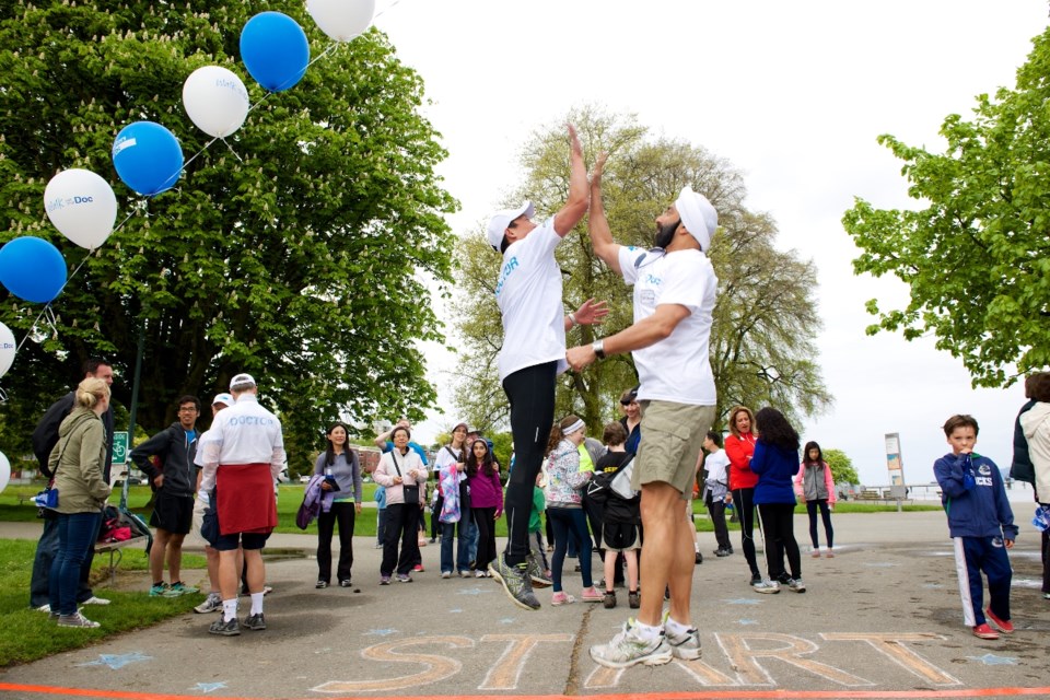 Dr. Davidicus Wong high-fives Dr. Baldev Sanghera at the end of the walk.