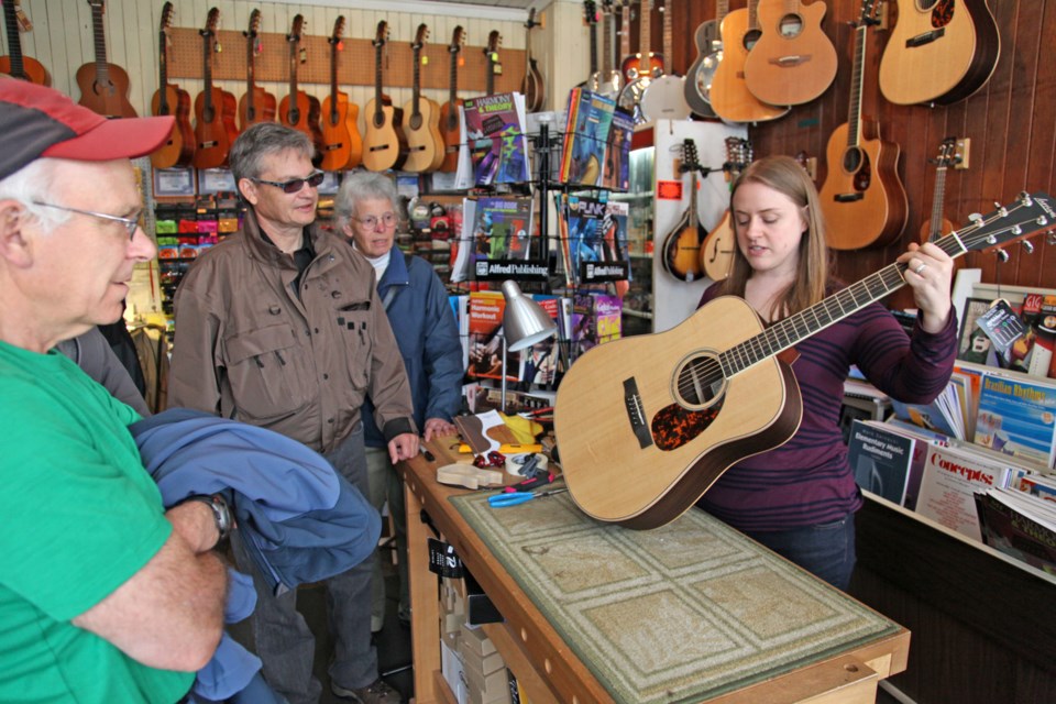 John Rance, Chuck Puchmayr and Mary Wilson get a demonstration from Liz Brabbins at the Neil Douglas Guitar Shop on the Jane's Walk on 12th Street on Sunday, May 4.