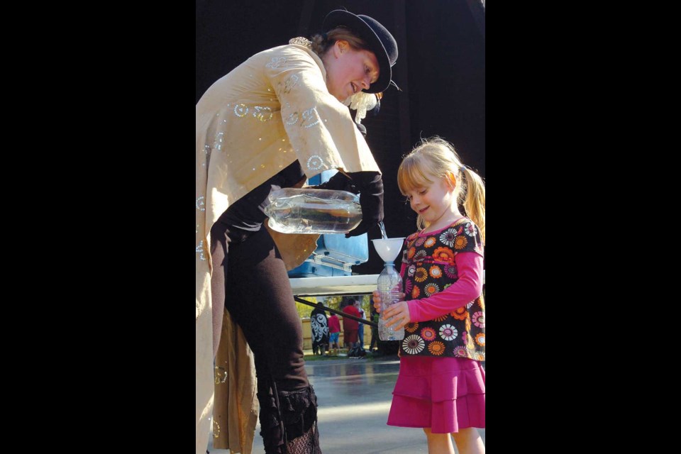 Dandelion intrepreter Mary Forbes does a water bottle demonstration with audience member Hannah Rickards, 4.