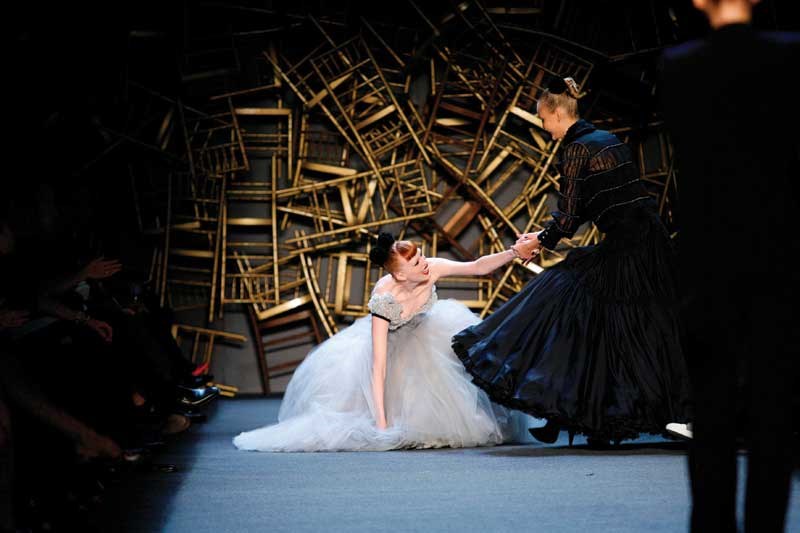 In this Feb. 7, 2008 file photo, one model helps another up after she fell while walking the runway during the showing of Zac Posen's Fall 2008 collection at Fashion Week in New York. (AP Photo/Kathy Willens, File)