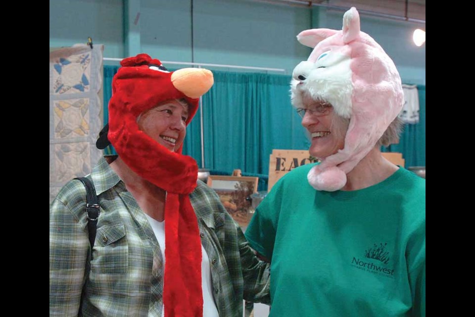 Roma Tingle, left, and Lynn Wilson, had a laugh as they tried on animal character hats at the Moon Glow booth at the PGX Thursday.<br>Aug. 10. 2012<br>Citizen photo by David Mah