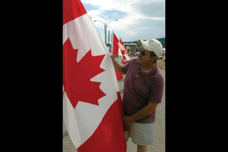 John Smith lines up some of the 158 Canadian flags at the Central BC Railway and Forestry Museum display. Each flag represents a Canadian soldier lost in Afganistan.<br>Aug. 09. 2012<br>Citizen photo by David Mah
