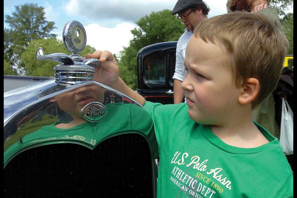 Benjamin Wood, 5, takes a close look at an emblem on a 1931 Ford pickup.