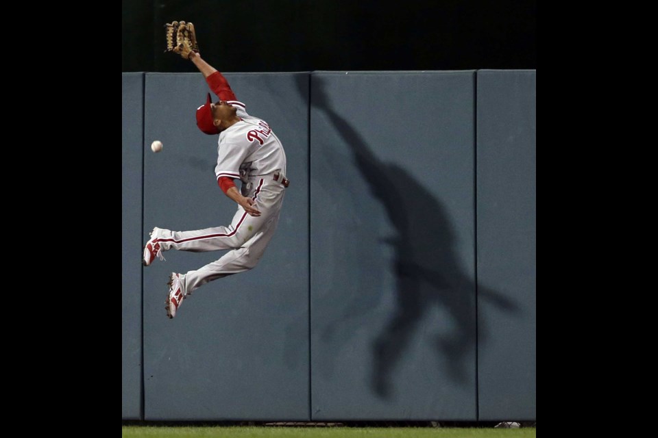 Philadelphia Phillies center fielder Ben Revere (2) cannot catch a one-RBI triple hit by Washington Nationals' Adam LaRoche during the fifth inning of a baseball game at Nationals Park, Friday, May 24, 2013, in Washington. (AP Photo/Alex Brandon)