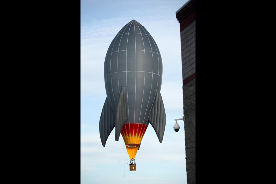 Hot air balloon pilot Forey Walters and a passenger rocket their balloon past buildings in Walla Walla, Wash., during the annual Walla Walla Balloon Stampede on Saturday, May 11, 2013. (AP Photo/Walla Walla Union-Bulletin, Jeff Horner)