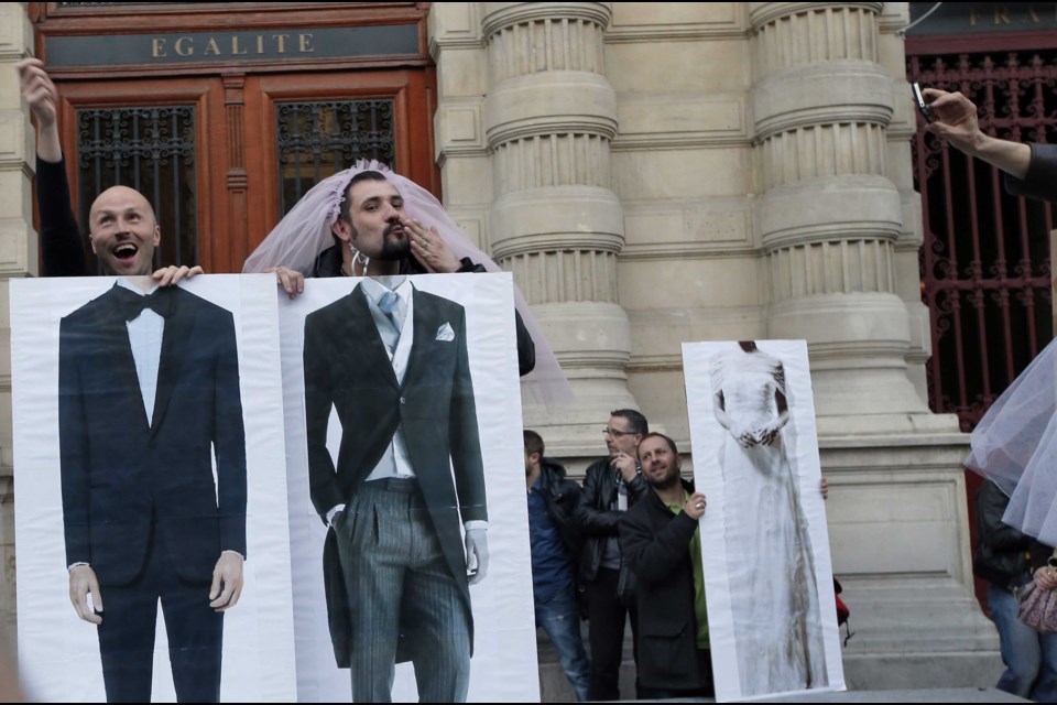Pro-gay marriage activists pose during a gathering at Paris 4th district city hall after French lawmakers legalized same-sex marriage, Tuesday, April 23, 2013 in Paris.  (AP Photo/Francois Mori)