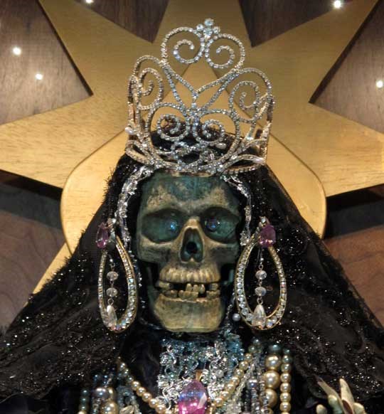In this Feb. 12, 2013 photo, a statue of La Sante Muerte from an altar run by Arely Vazquez Gonzalez, a Mexican immigrant and transgender woman, is shown at inside a Queens, NY apartment.  La Santa Muerte, an underworld saint most recently associated with the violent drug trade in Mexico, now is spreading throughout the U.S. among a new group of followers ranging from immigrant small business owners to artists and gay activists. In addition to showing up at drug crime scenes, the once-underground icon has been spotted on passion candles in Richmond, Va. grocery stores. The folk saint's image can be seen inside New York City apartments, in Minneapolis religious shops and during art shows in Tucson, Ariz.  (AP Photo/Russell Contreras)