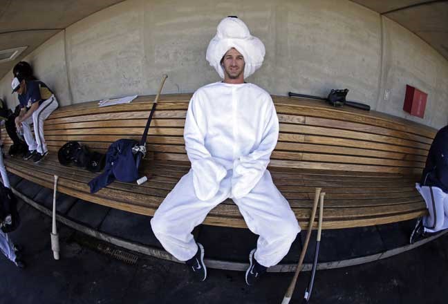 In this image taken with a fisheye lens, Milwaukee Brewers' Darren Byrd wears a polar bear costume in the dugout during a spring training baseball workout Friday, Feb. 22, 2013, in Phoenix. Four Brewers players, who are playing for Canada in the World Baseball Classic, wore costumes to the practice. (AP Photo/Morry Gash)