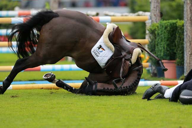 German show jumper Andreas Kreuzer, right, falls off his horse Balounito during the Prize of NorthÂ Rhine-Westphalia, a show jumping event at CHIO equestrian meeting Â in Aachen, Germany, Friday June 28, 2013. (AP Photo/dpa,Rolf Vennenbernd)